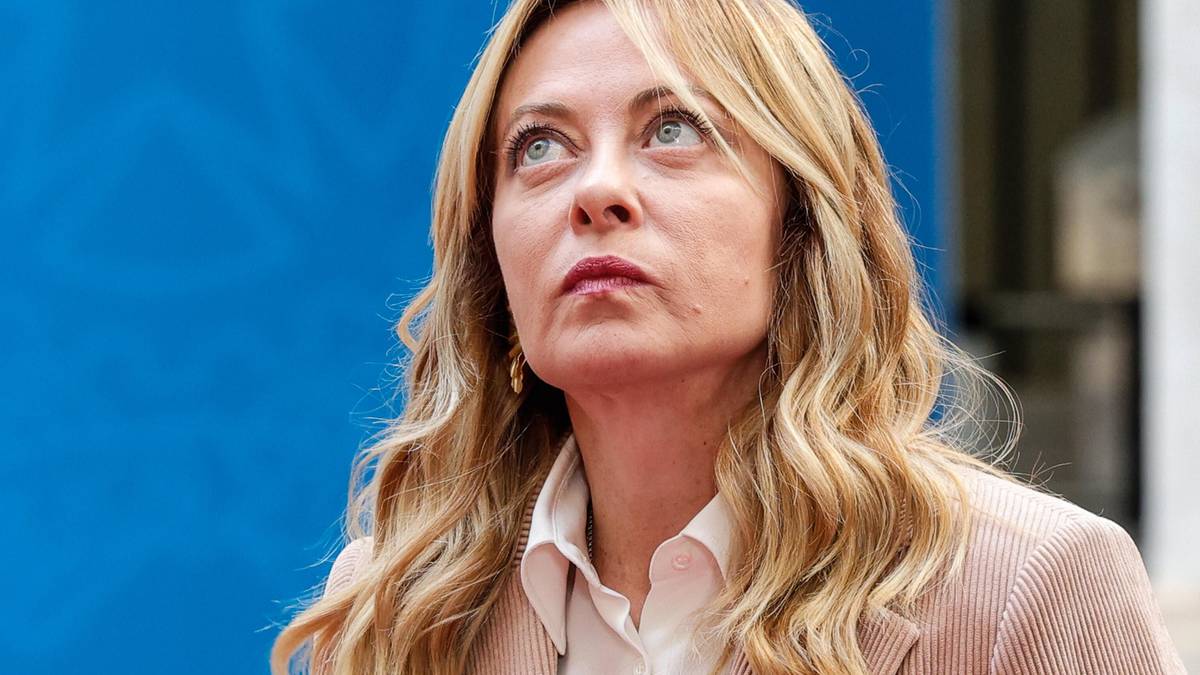 Portret kobiety, premier Włoch Giorgii Meloni, patrzącej w g&oacute;rę z poważnym wyrazem twarzy.