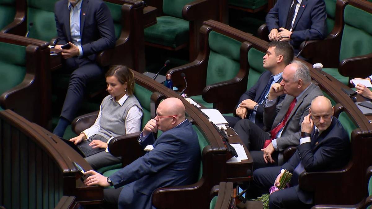 Posłowie siedzący w ławach sejmowych podczas obrad.