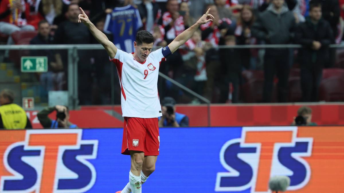 Robert Lewandowski w stroju reprezentacji Polski celebruje gol z uniesionymi rękoma.
