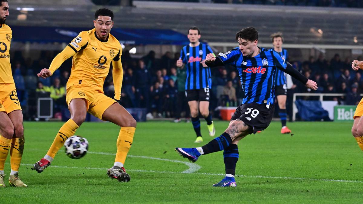 Dwóch piłkarzy walczy o piłkę na boisku piłkarskim.