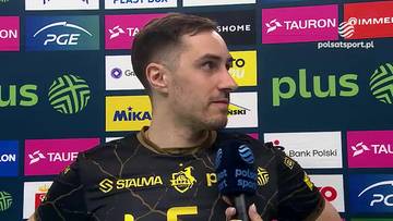 Mateusz Malinowski, siatkarz, ubrany w czarną koszulkę sportową, trzyma mikrofon Polsat Sport.