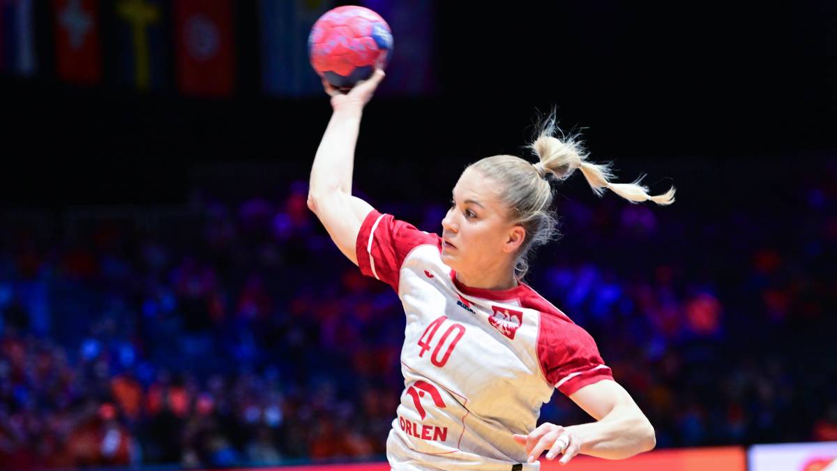Piłkarka ręczna w białej koszulce z czerwonymi rękawami i numerem 40, wykonująca rzut.