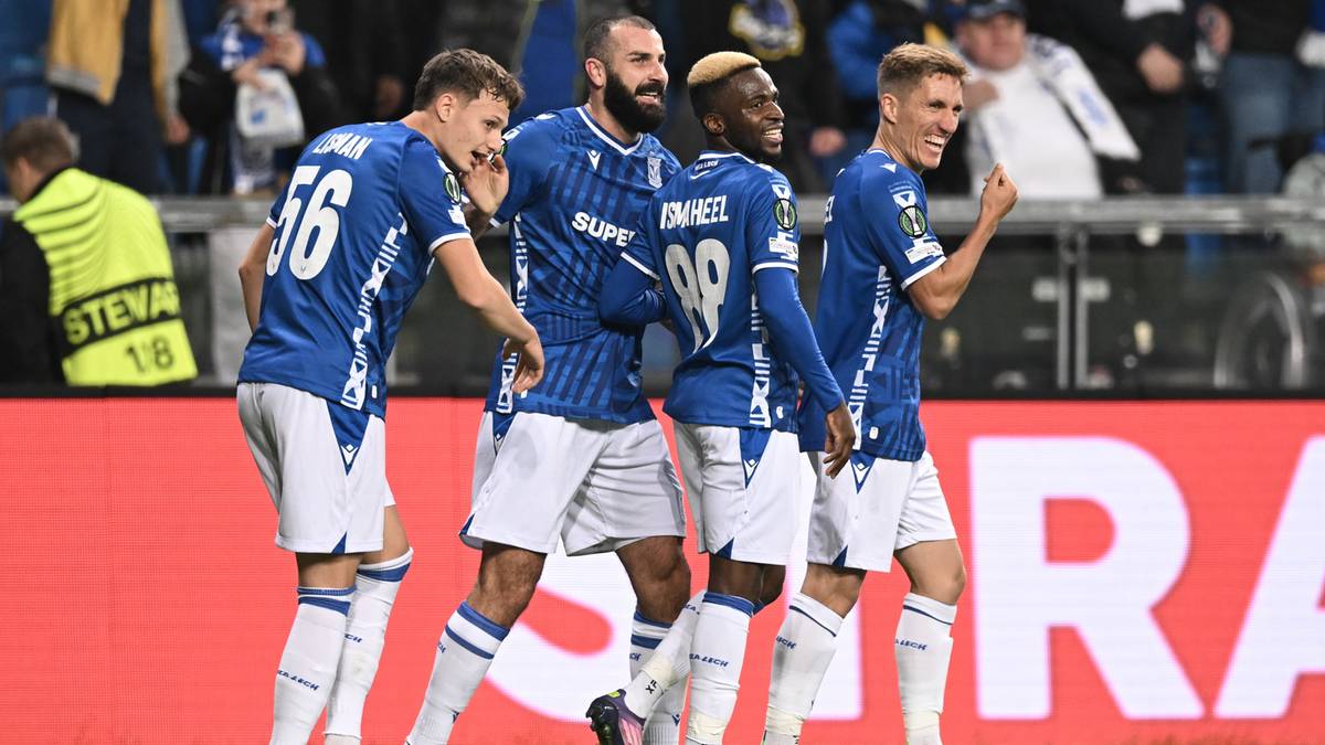 Czterech piłkarzy Lecha Poznań w niebieskich strojach świętuje zdobycie gola na stadionie.