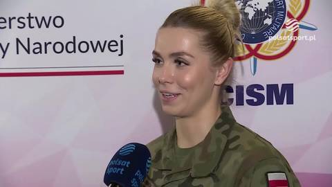 Klaudia Adamek w mundurze wojskowym przed mikrofonem.