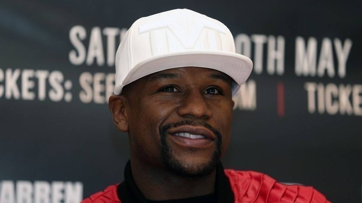 Floyd Mayweather w białej czapce z daszkiem i czerwonej bluzie.