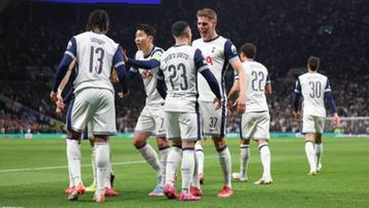 Piłkarze Tottenhamu w białych strojach świętują bramkę na boisku piłkarskim.