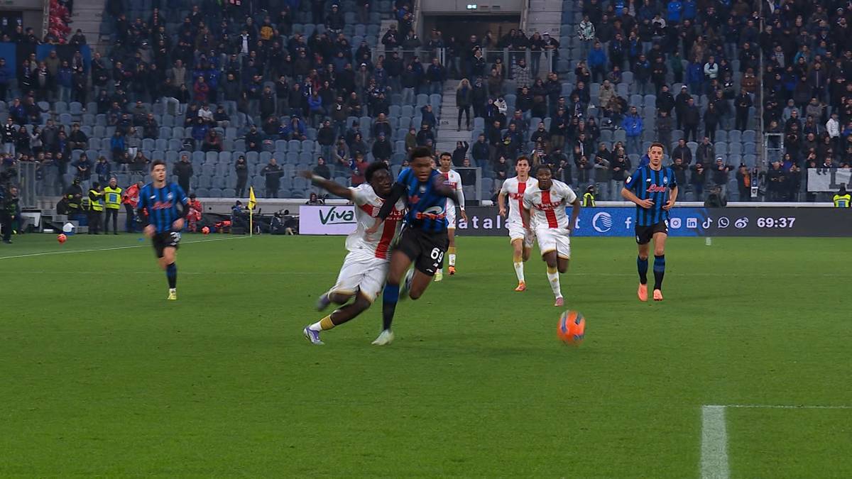 Dwóch piłkarzy walczy o piłkę na boisku podczas meczu.