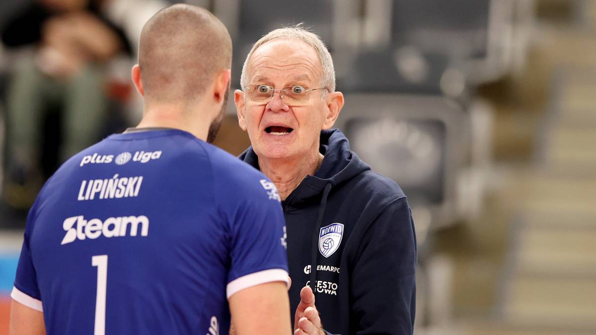 Dwóch mężczyzn w strojach siatkarskich. Jeden z nich, zwrócony tyłem do widza, ma na plecach napis "Lipiński" i numer "1". Drugi, starszy mężczyzna w okularach, zwraca się do niego, gestykulując rękami.