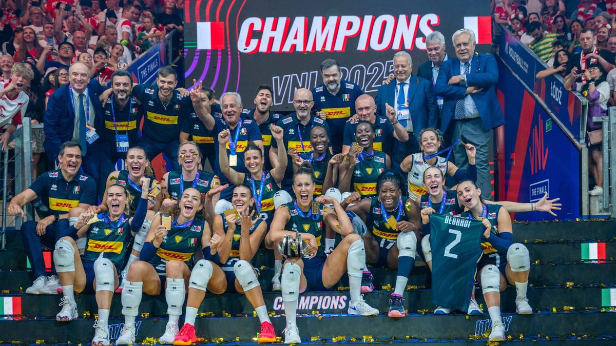 Siatkarki świętują zwycięstwo Mistrzostw Świata, pozując do zdjęcia z pucharem i flagami.