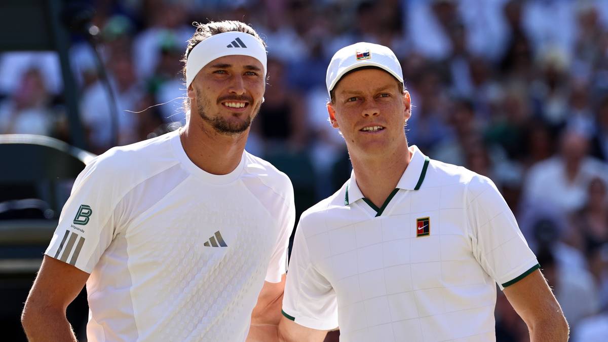 Dw&oacute;ch tenisist&oacute;w w białych strojach sportowych na korcie tenisowym z rakietami w dłoniach.