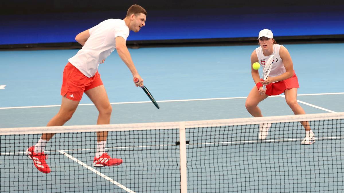 Dw&oacute;ch zawodnik&oacute;w tenisa na korcie, przygotowujących się do odbicia piłki.