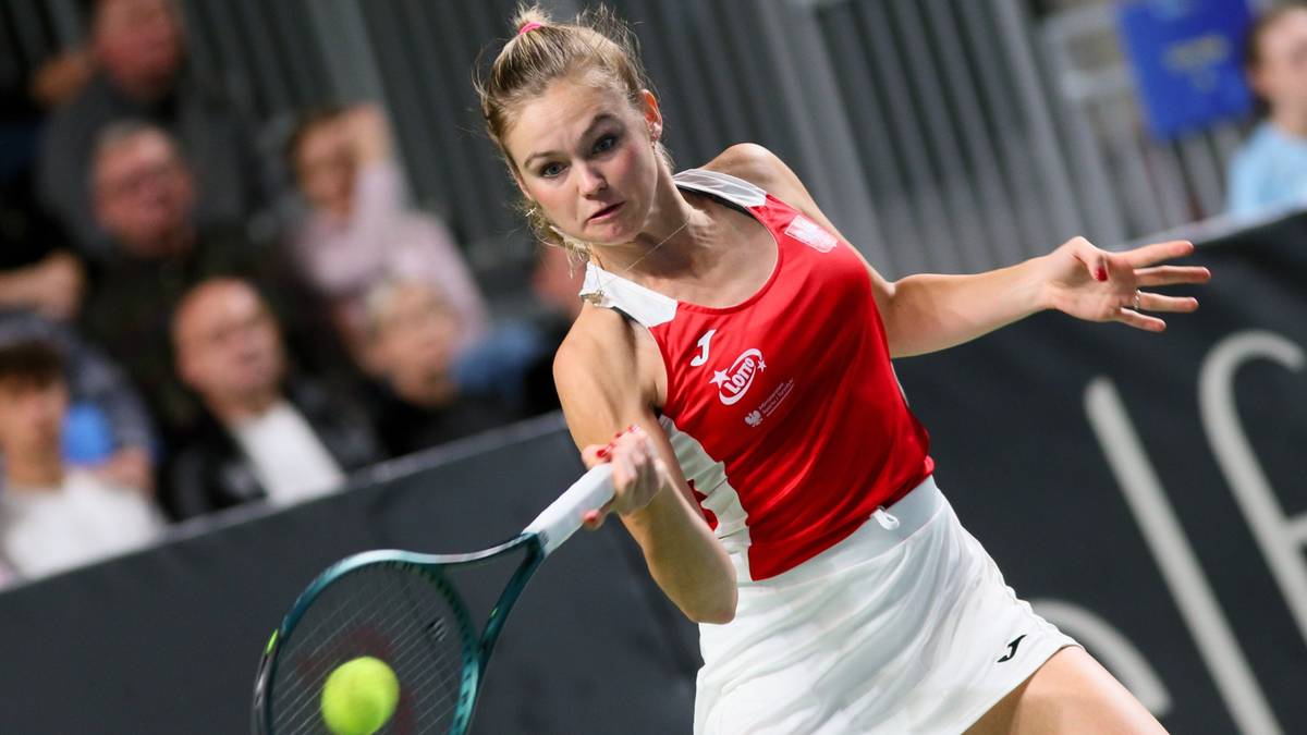 Tenisistka Linda Klimovicova podczas meczu, uderzająca piłkę rakietą.