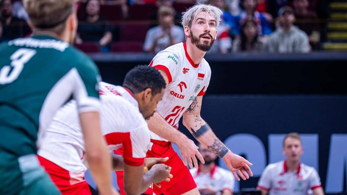 Siatkarz Tomasz Fornal w białej koszulce z czerwonymi elementami, zapatrzony w bok, podczas meczu.