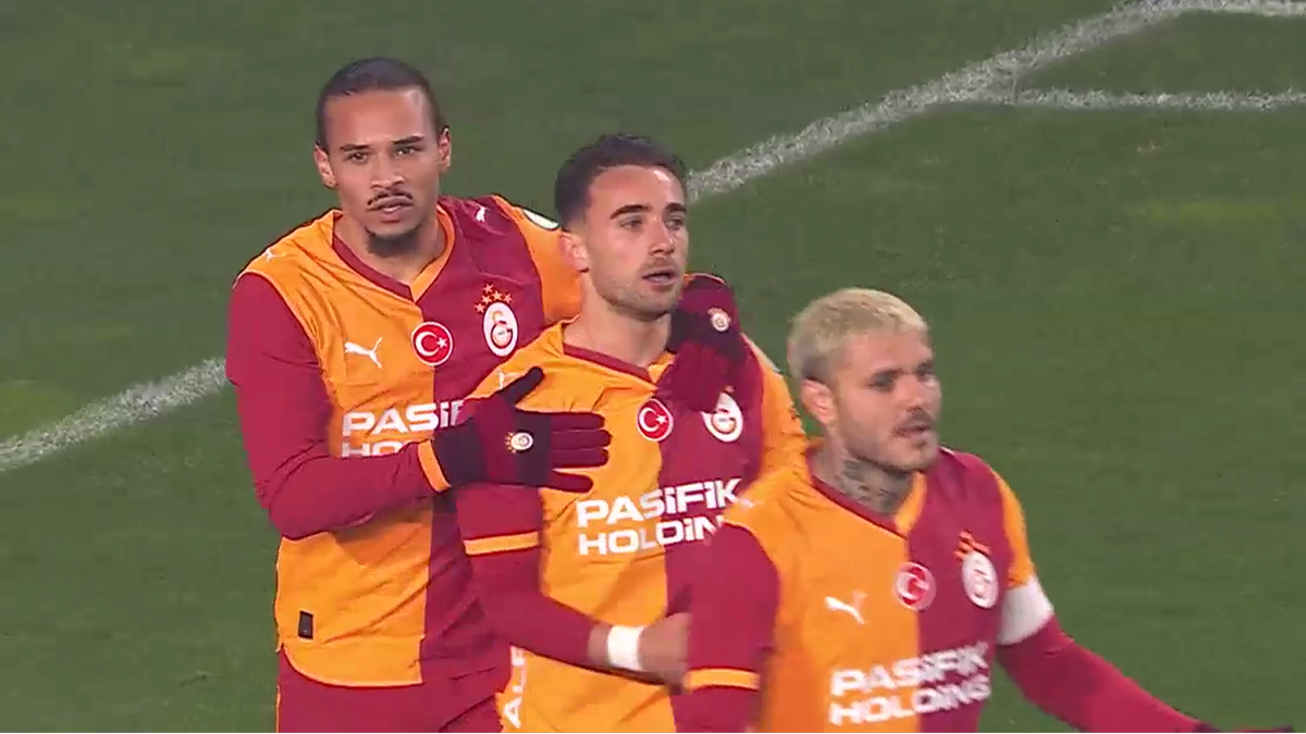 Trzech piłkarzy Galatasaray świętujących bramkę na boisku piłkarskim.