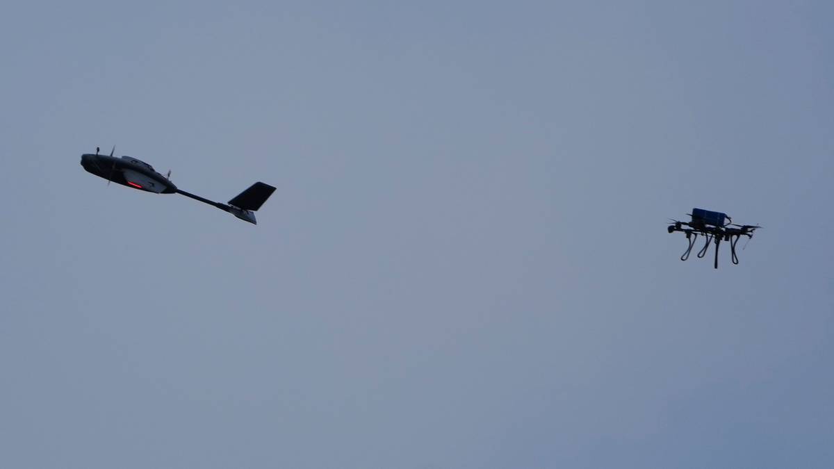 Dwa drony lecące na tle błękitnego nieba.