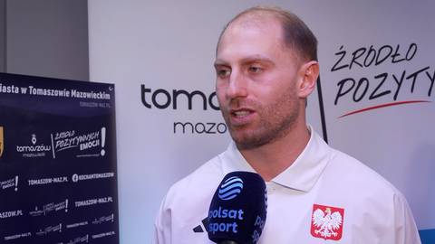 Damian Żurek udziela wywiadu do mikrofonu Polsatu Sport. Na jego piersi widnieje godło Polski.