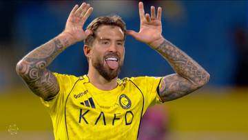 Piłkarz w ż&oacute;łtej koszulce podczas meczu pokazuje zabawny gest, wysuwając język.