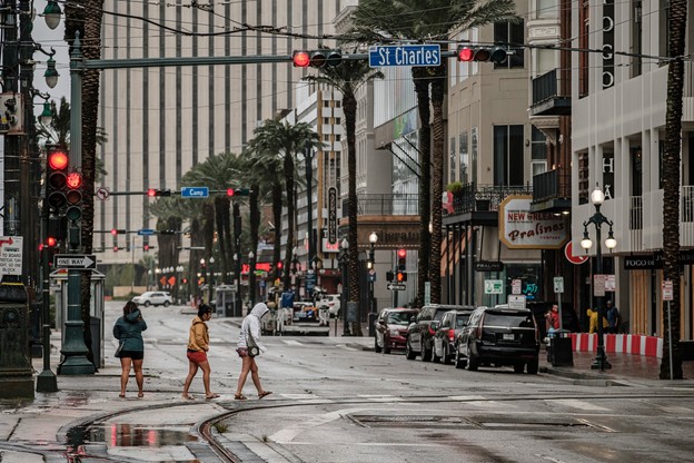 Grupa kobiet przechodzi przez Canal Street w centrum miasta, gdy chmury i wiatr z huraganu Ida wpadają do Nowego Orleanu