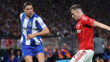 Dwóch piłkarzy w akcji na zielonej murawie stadionu, jeden w niebiesko-białym stroju FC Porto, drugi w czerwonym stroju Nottingham Forest.