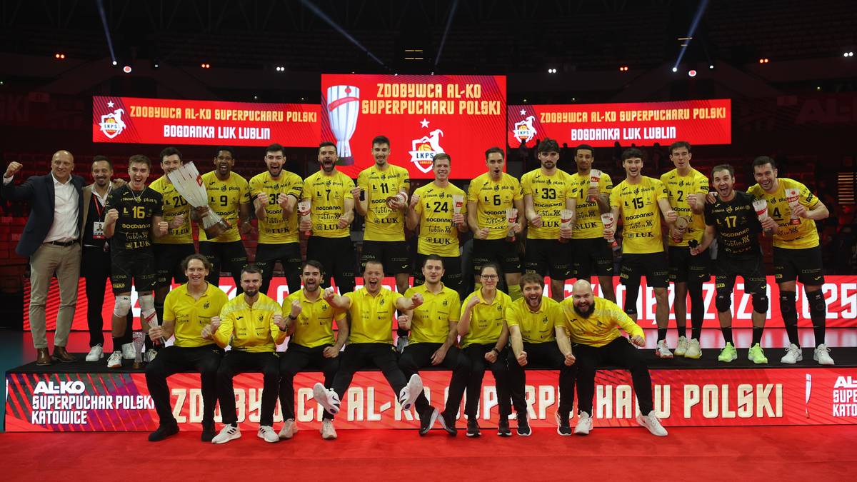 Drużyna siatkarzy Bogdanki LUK Lublin w żółtych strojach na podium z pucharem po wygranym meczu AL-KO Superpucharu Polski.