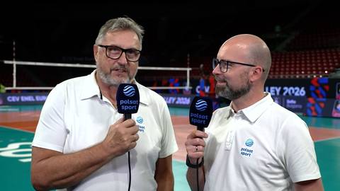 Wojciech Drzyzga i drugi dziennikarz z mikrofonami Polsat Sport w hali siatkarskiej.