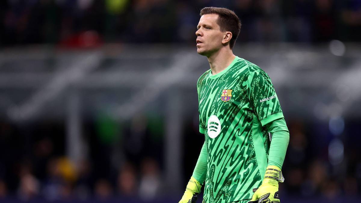 Bramkarz w zielonej koszulce z żółtymi rękawicami stoi na boisku.