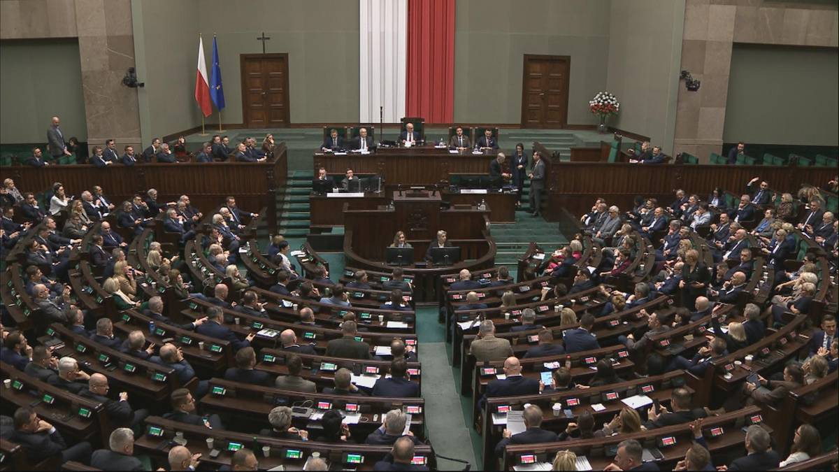 Widok z góry na salę plenarną Sejmu podczas głosowania, z widocznymi rzędami posłów siedzących w ławach.