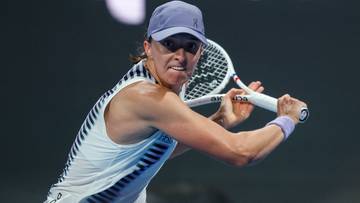 Iga Świątek podczas meczu tenisowego, wykonująca forhend.