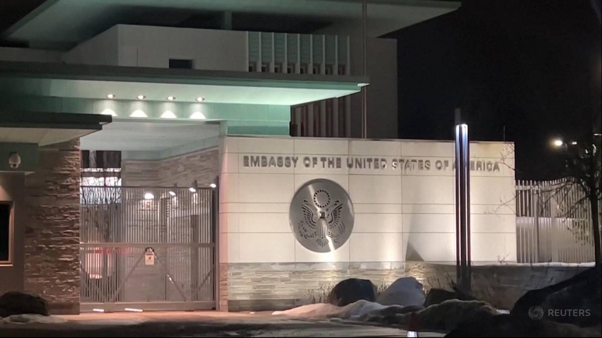 Budynek ambasady Stan&oacute;w Zjednoczonych Ameryki w Oslo nocą, oświetlony z widocznym logo ambasady.