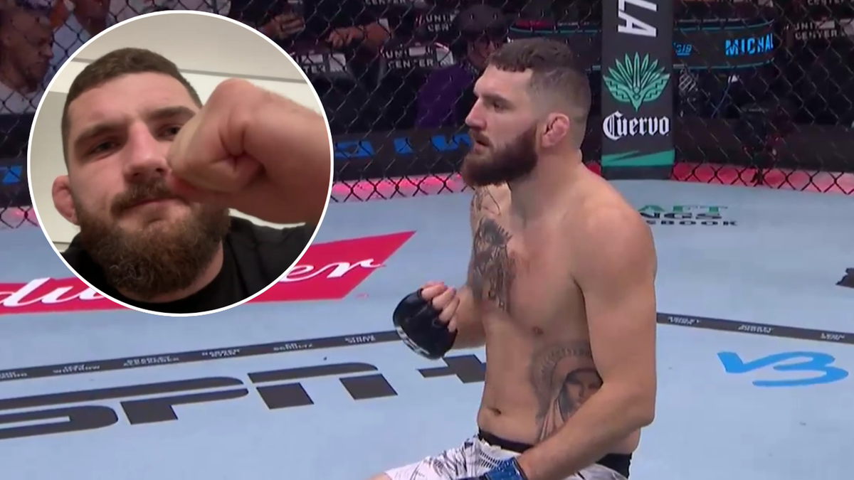 Dwóch mężczyzn z brodami w klipie wideo, jeden w zbliżeniu zaciskający pięść, drugi w pełnej postaci siedzący na macie w ringu.