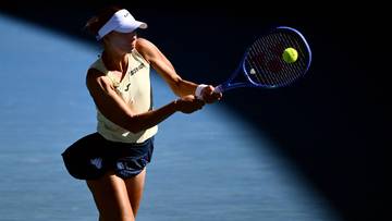 Tenisistka odbija piłkę rakietą w trakcie meczu.