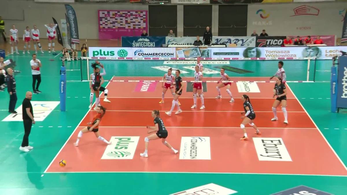 Drużyna siatkarek grająca mecz w hali sportowej.