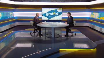 Dw&oacute;ch mężczyzn rozmawia w studiu telewizyjnym, na ekranie za nimi logo "graffiti".