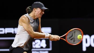 Tenisistka w akcji, uderzająca piłkę rakietą podczas meczu na korcie.