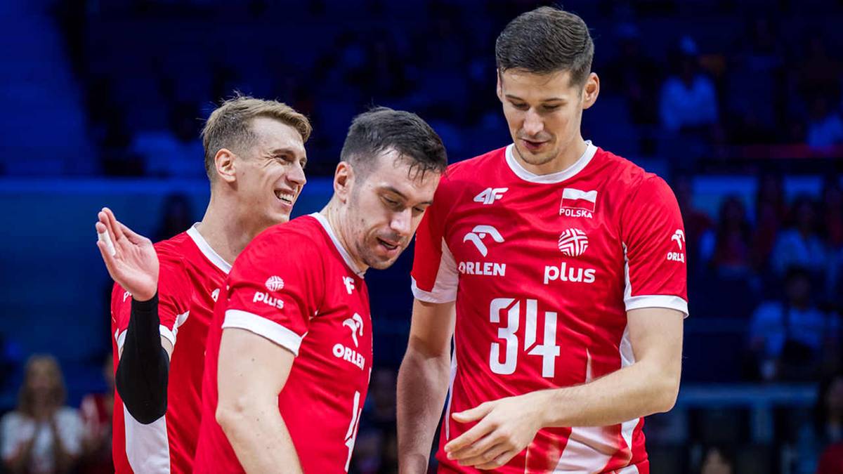 Trzech siatkarzy w czerwonych koszulkach z białymi numerami i logiem "ORLEN PLAY"