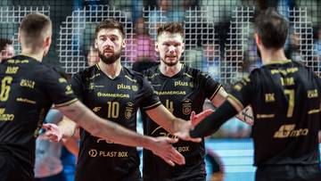 Siatkarze w czarnych koszulkach z żółtymi akcentami gratulują sobie nawzajem po meczu.