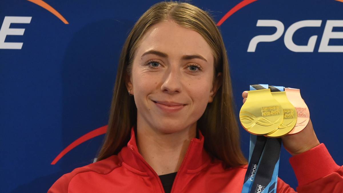 Klaudia Zwolińska pozuje z trzema medalami (złotym, srebrnym i brązowym) na szyi, uśmiechając się do kamery. Jest ubrana w czerwony strój sportowy.
