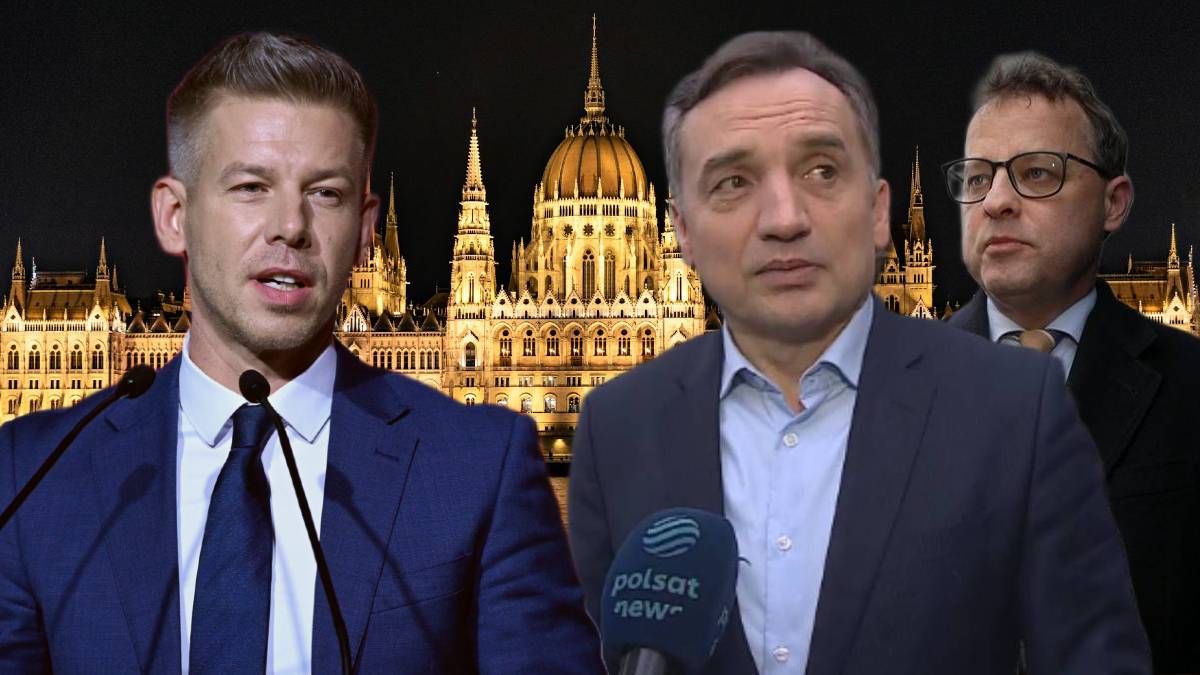 Dw&oacute;ch mężczyzn w garniturach, jeden m&oacute;wiący do mikrofonu, na tle nocnego budynku węgierskiego parlamentu.