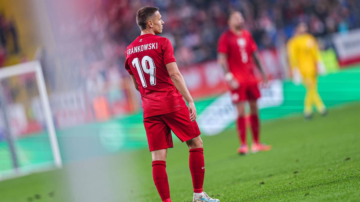 Piłkarz w czerwonej koszulce z numerem 19 na plecach opuszcza boisko.