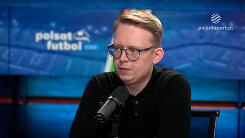 Adrian Siemieniec w okularach i czarnej koszulce siedzi i m&oacute;wi do mikrofonu, na tle widnieje logo "Polsat Futbol".