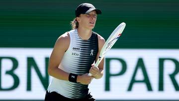 Iga Świątek podczas meczu tenisowego, trzymająca rakietę.