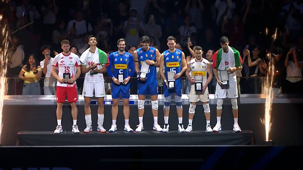 Siedmiu siatkarzy w strojach sportowych stoi na podium. Wszyscy otrzymali nagrody indywidualne, a większość trzyma trofea. Dwóch z nich nosi białe koszulki z czerwonymi numerami, jeden białą koszulkę z zielonymi i czerwonymi elementami, a czterech niebieskie koszulki z żółtymi detalami.