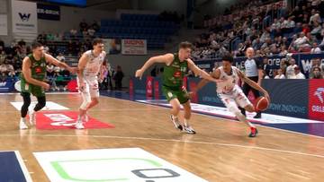 Gracze koszykówki walczą o piłkę na parkiecie.