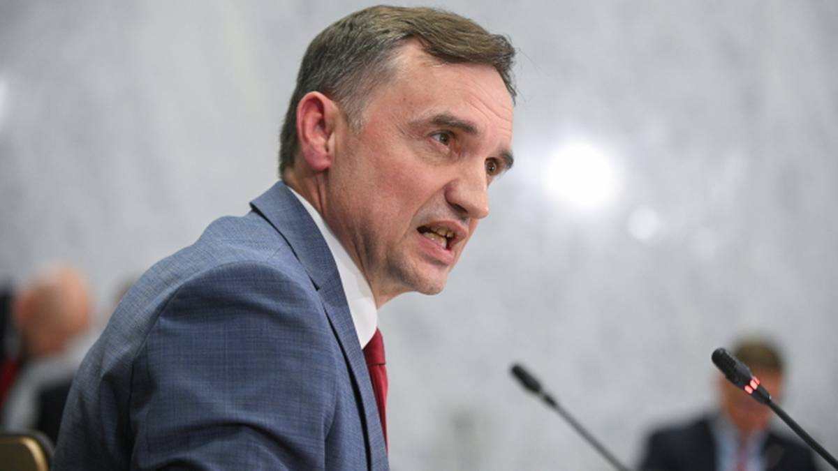 Zbigniew Ziobro, ubrany w niebieski garnitur i czerwoną koszulę, mówi z wyraźną emocją podczas przesłuchania.