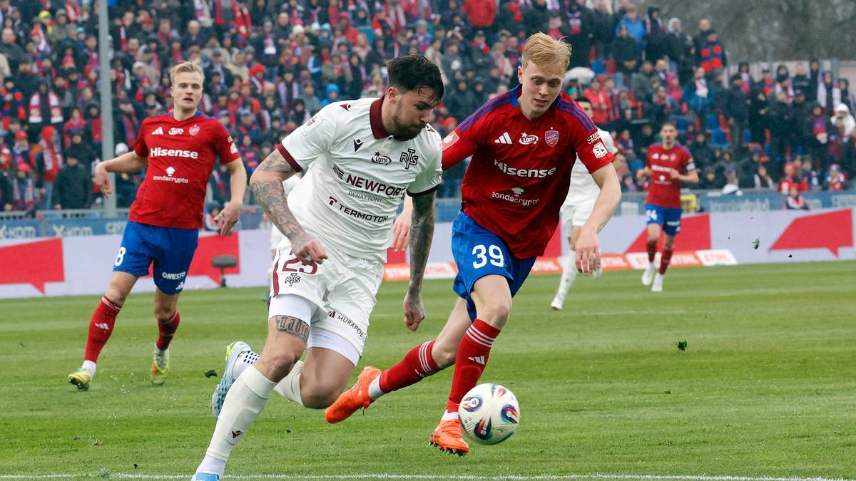 Dw&oacute;ch piłkarzy walczących o piłkę na boisku podczas meczu.