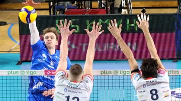 Siatkarz wykonujący zagrywkę podczas meczu siatkówki.