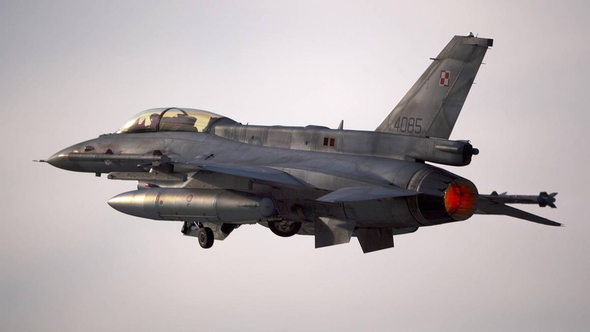 Samolot myśliwski F-16 w locie, z widocznym silnikiem i uzbrojeniem pod skrzydłami.