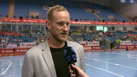 Mężczyzna w jasnej marynarce udziela wywiadu.