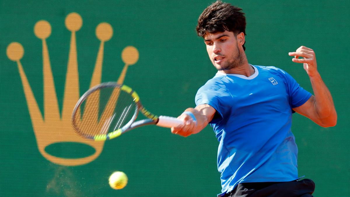 Carlos Alcaraz wykonujący forhend podczas meczu tenisowego, w tle logo Rolex.