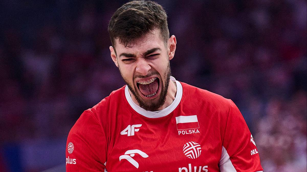 Mężczyzna w czerwonej koszulce reprezentacji Polski z otwartymi ustami, krzyczący podczas meczu siatk&oacute;wki.